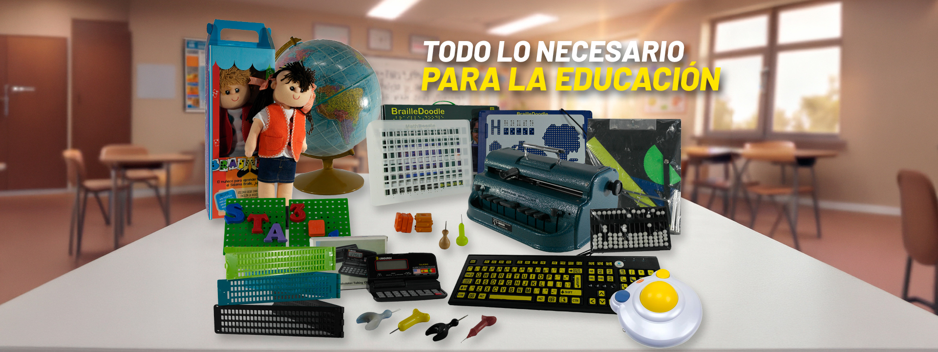 Una vista de aula con un escritorio blanco en primer plano lleno de herramientas educativas para ciegos y deficientes visuales: máquina de escribir Braille, mapa táctil, muñecos, calculadoras, punzones y un teclado. Fondo desenfocado.